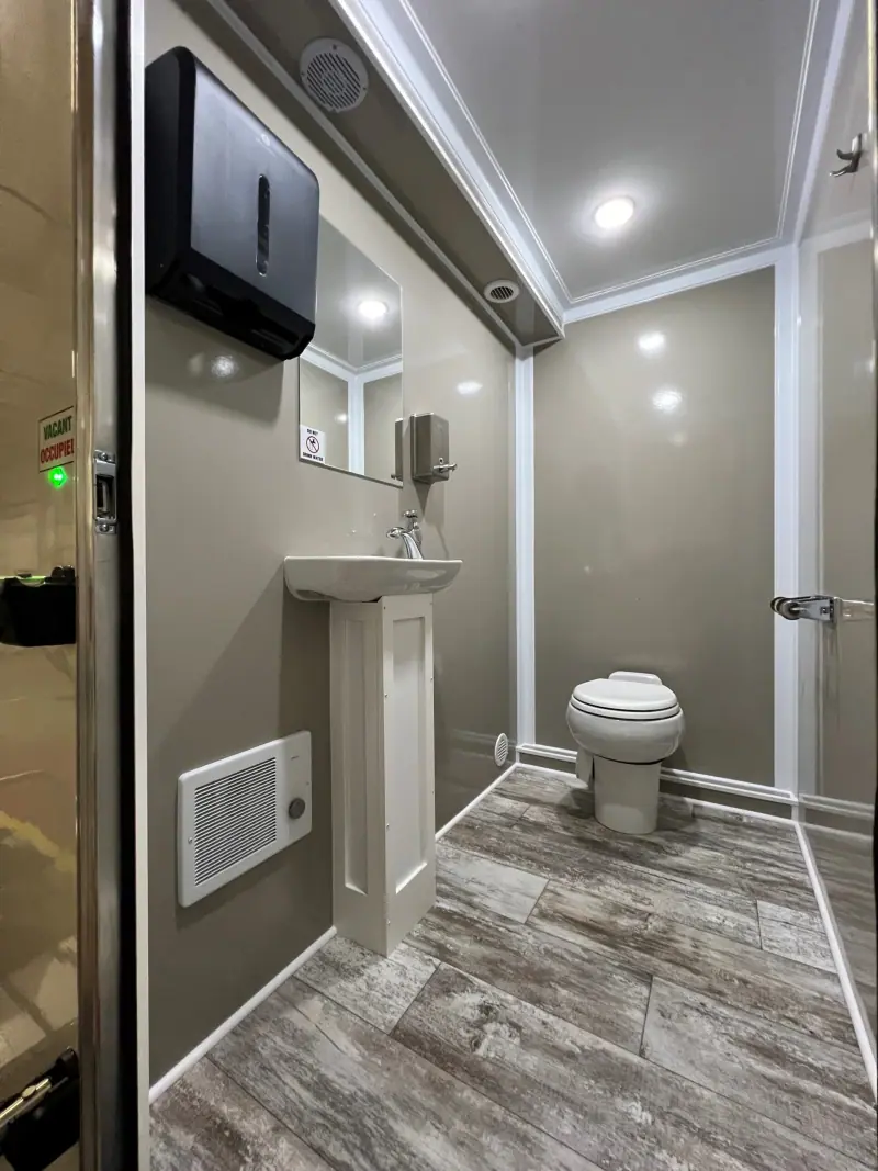 Private restroom with a pedestal sink and wood-look floor
