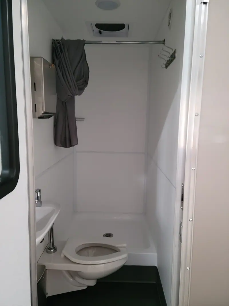 Combo room with a toilet and a shower behind one door