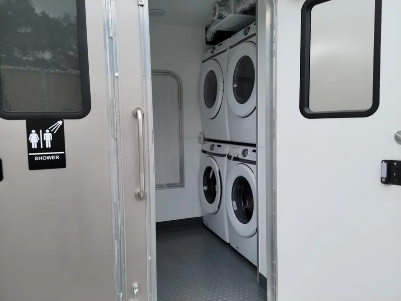 Stacked washers and dryers next to the shower room door