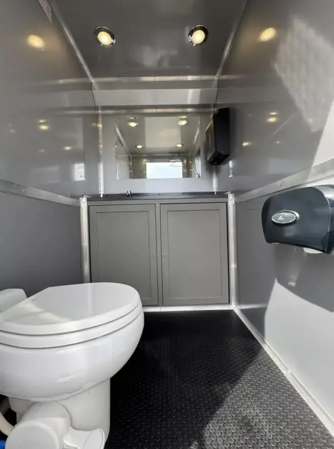 Women’s room with a toilet, sink and dispensers