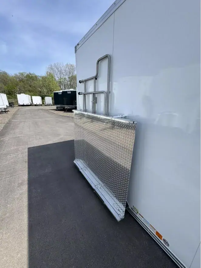 An ADA+2 Restroom Trailer (20' x 6') with a metal ramp is positioned on an asphalt lot, alongside other visible trailers.