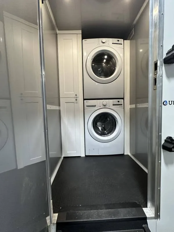 A 2 private room shower restroom trailer is set up in a clean, narrow space with amenities on either side for convenience and privacy.
