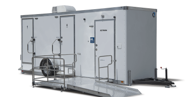 A portable restroom trailer with three doors, including accessible entry with a ramp, air conditioning unit on top, and a white exterior.
