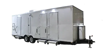 A large white shower restroom trailer with multiple doors, steps, and wheels is shown against a plain background.